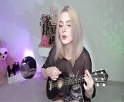 Hot blonde girl playing on ukulele and singing in naughty outfit from behind dogo niga singeli